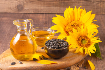 Sunflower oil and sunflower seeds on traditional rustic wooden background. Organic and eco food concept. Healthy food and fats.