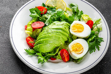 Avocado salad, boiled egg, tomato, green leaf lettuce, vegetable dish fresh delicious gourmet food background on the table rustic food top view copy space keto and paleo diet vegetarian food