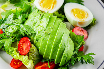 Avocado salad, boiled egg, tomato, green leaf lettuce, vegetable dish fresh delicious gourmet food background on the table rustic food top view copy space keto and paleo diet vegetarian food