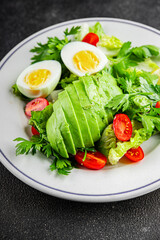 Avocado salad, boiled egg, tomato, green leaf lettuce, vegetable dish fresh delicious gourmet food background on the table rustic food top view copy space keto and paleo diet vegetarian food