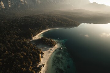 Serene alpine lake nestled amongst misty mountains.  Tranquil shoreline with sandy beach and lush forest