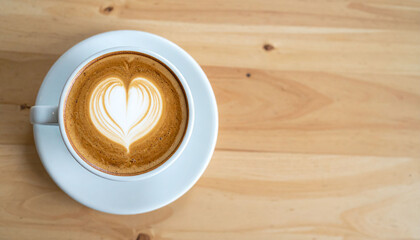 Obraz premium the scene presents a top down view of a cup filled with a frothy beverage, resting on a matching saucer. the beverage displays an artistic design, resembling a heart created with the foam