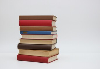 Stack of books with different colors and sizes on a white background in a studio setting display