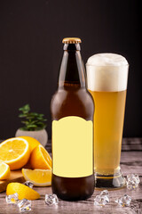 Cold beer bottle and foamy beer glass with lemon slices and ice cubes on rustic wooden table against black background. Ideal for summer drink ads, beverage branding or refreshing lifestyle promotions