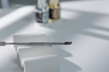 Elegant arrangement of manicure tools on light surface, professional salon close-up