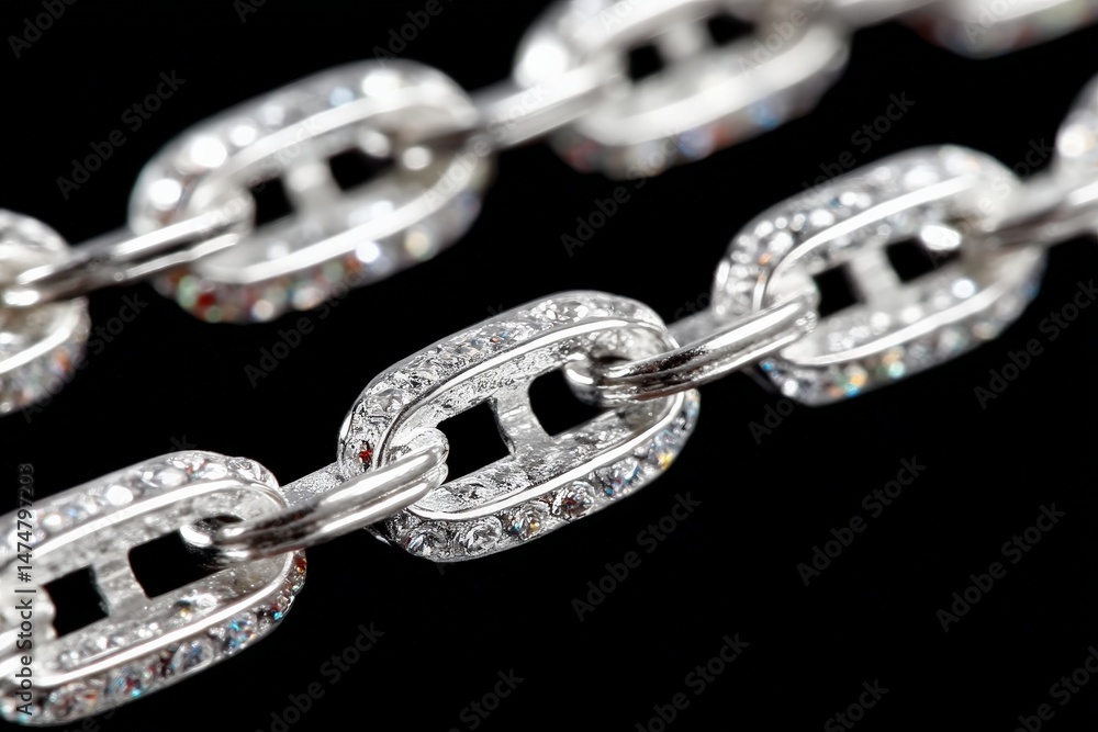 Poster close-up view of sparkling silver jewelry chain with intricate links and shiny details against a dar