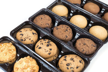 Various round cookies in an open box. Cookies in a pack on white