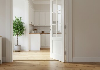 View of a white kitchen through an open door with a plant in the foreground and wood flooring shown