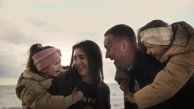 family of dad, mum and daughters at seaside