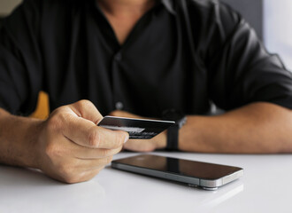Online Payment with Credit Card on Laptop by Man in Black Shirt