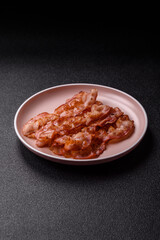 Cooked crispy bacon, slices of roast pork for an English breakfast. Fried bacon