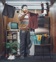 Man living alone in a micro apartment and doing the laundry