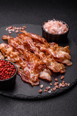Cooked crispy bacon, slices of roast pork for an English breakfast. Fried bacon