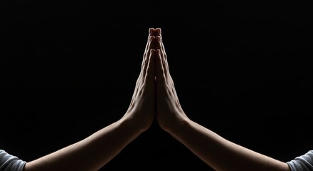 Hands in Prayer Position on Black Background