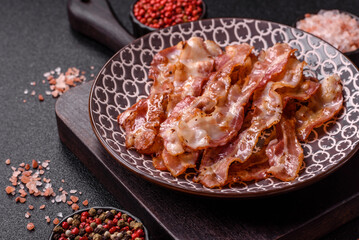 Cooked crispy bacon, slices of roast pork for an English breakfast. Fried bacon