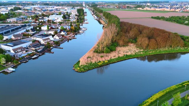 Beautiful picturesque village with canals instead of roads. Drone flight over the waterscape, fields and woods of Vinkeveen, the Netherlands.