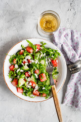 A light appetizer or an elegant side dish. Salad prepared with arugula, enriched with feta, and pieces of watermelon and cucumber.