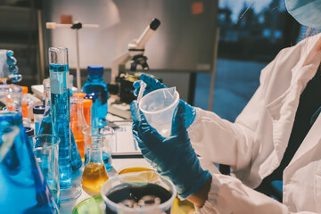 Scientist pipetting medical samples into microplate in laboratory