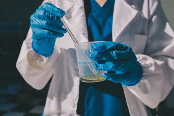 Scientist pipetting medical samples into microplate in laboratory