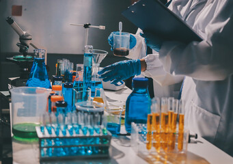 Scientist pipetting medical samples into microplate in laboratory