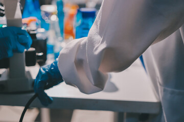 Scientist pipetting medical samples into microplate in laboratory
