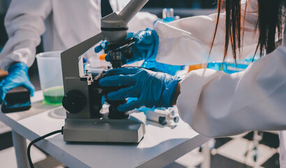 Scientist pipetting medical samples into microplate in laboratory