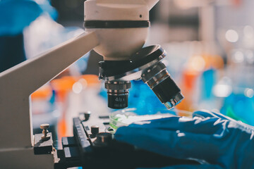 Scientist pipetting medical samples into microplate in laboratory