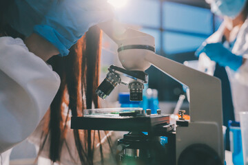 Scientist pipetting medical samples into microplate in laboratory