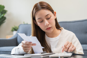 Business financial concept, stressed asian young woman checking list statement of credit card for...