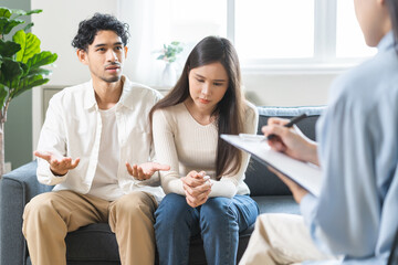 Psychology, depression asian young couple love woman and male patient consulting problem mental health with psychologist, psychiatrist at clinic together, wife encouraging husband, therapy health care