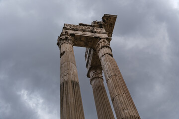 Ancient Roman column in Rome, Italy against a dark, cloudy sky