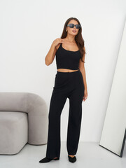 Elegant woman poses in stylish fashion attire in modern studio setting