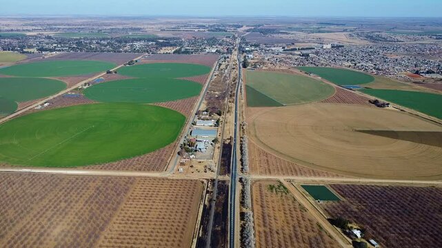 Aerial view of agricultural fields with circular irrigation patterns and a long straight road cutting through south africa