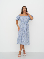 Elegant female model exhibits floral fashion in a bright studio setting