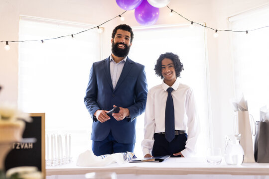 Diverse family, Smiling father and son in suits celebrating at home