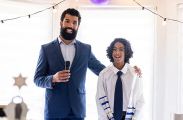 Diverse family, Father and son celebrating religious ceremony at home, both smiling happily