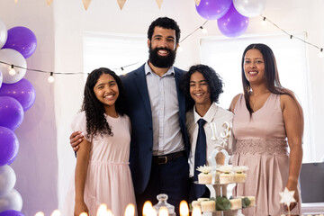 Celebrating religious milestone, diverse family with cake and decorations, smiling joyfully, at home