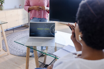 Discussing product launch, colleagues in modern office collaborating on presentation