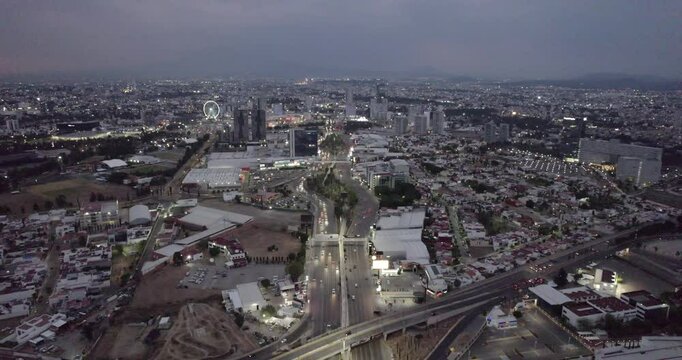 Trafico al atardecer en Puebla con el reflejo del edificio al lado izquierdo.