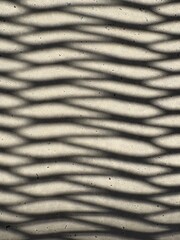 Shadow of a grid structure on a concrete surface