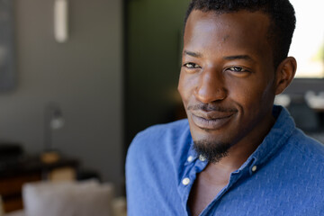 Smiling man in blue shirt enjoying relaxed moment at home
