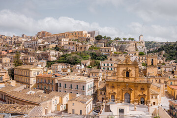 Naklejka premium Panoramic view of historic Modica in Sicily with baroque architecture, terracotta rooftops, and the Cathedral of Saint Peter. A UNESCO-listed gem in southern Italy