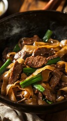sizzling beef horfun noodles with caramelized onions and scallions close-up view, stir fry beef noodle