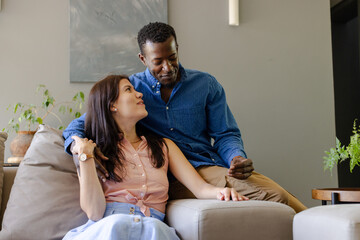 Couple relaxing on sofa at home, enjoying quality time together