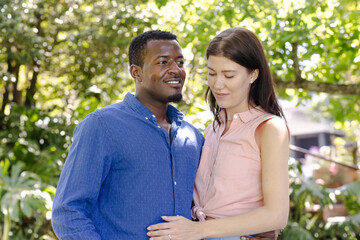 Fototapeta premium Couple embracing outdoors, smiling and enjoying sunny day in park