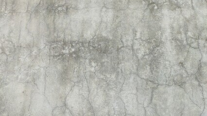 Rough grey concrete wall textured with detailed crack patterns, suitable for background and industrial themes.