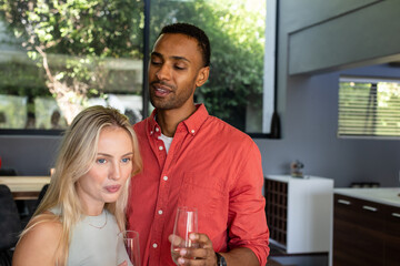 Couple drinking together at home during daytime celebration, smiling and talking