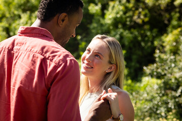 Fototapeta premium Couple holding hands outdoors, smiling and enjoying sunny day together