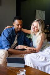 Happy couple watching tablet together at home, sharing joyful moments