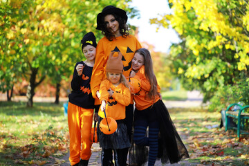 Happy family walk in the park on Halloween. Family dressed up in Halloween costumes